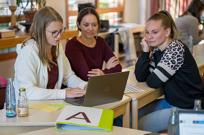Teilnehmende der DiaCampus Akademie arbeiten am Laptop zusammen